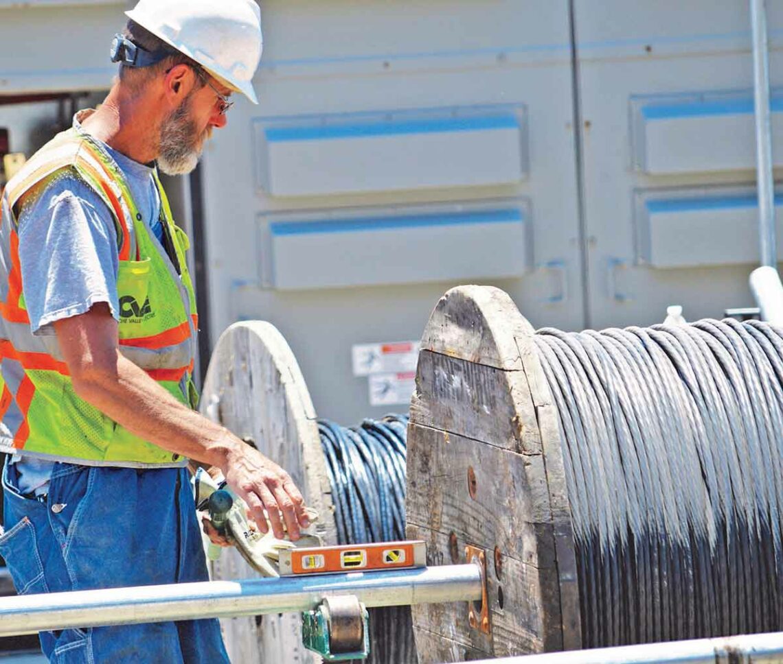 A man at a spool of cabling working on physical security integration